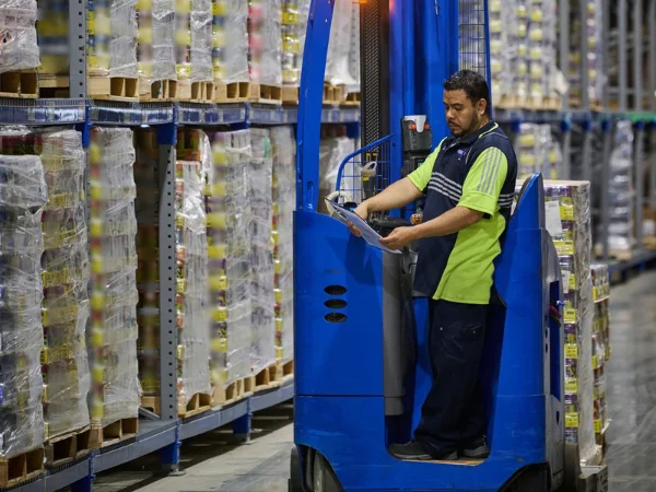 Reach truck driver picking food and beverage warehouse orders