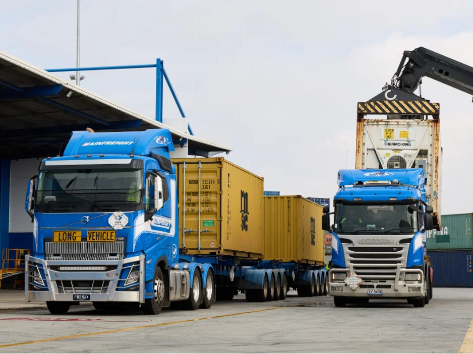 Wharf Cartage Container Transport - Two Mainfreight wharf cartage trucks being loaded with containers