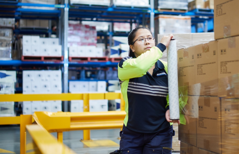 Mainfreight Global Supply Chain Logistics Services  - Mainfreight Supply Chain Logistics Services. Female team member wrapping pallet in warehouse. 